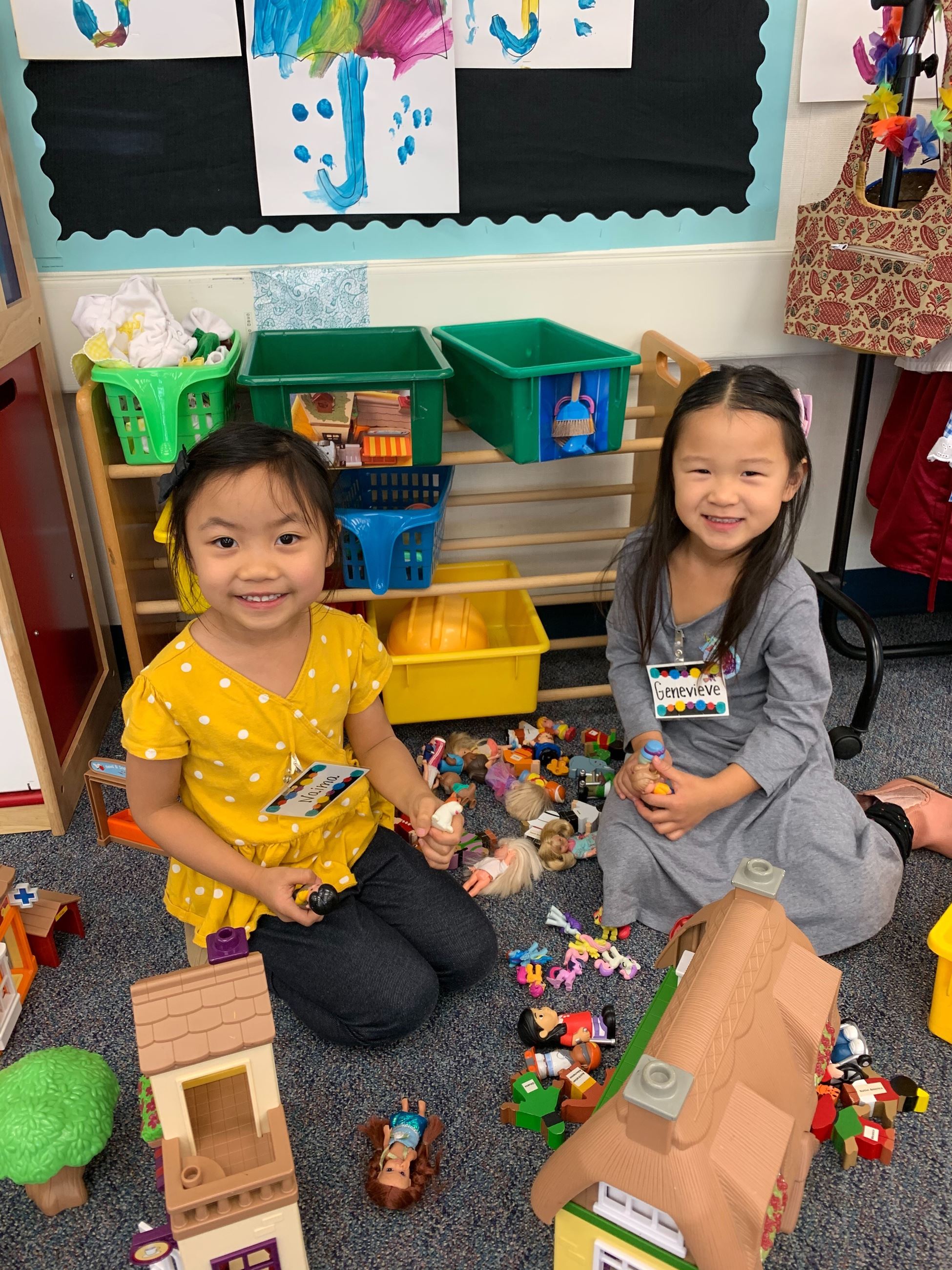 Two girls playing with doll house