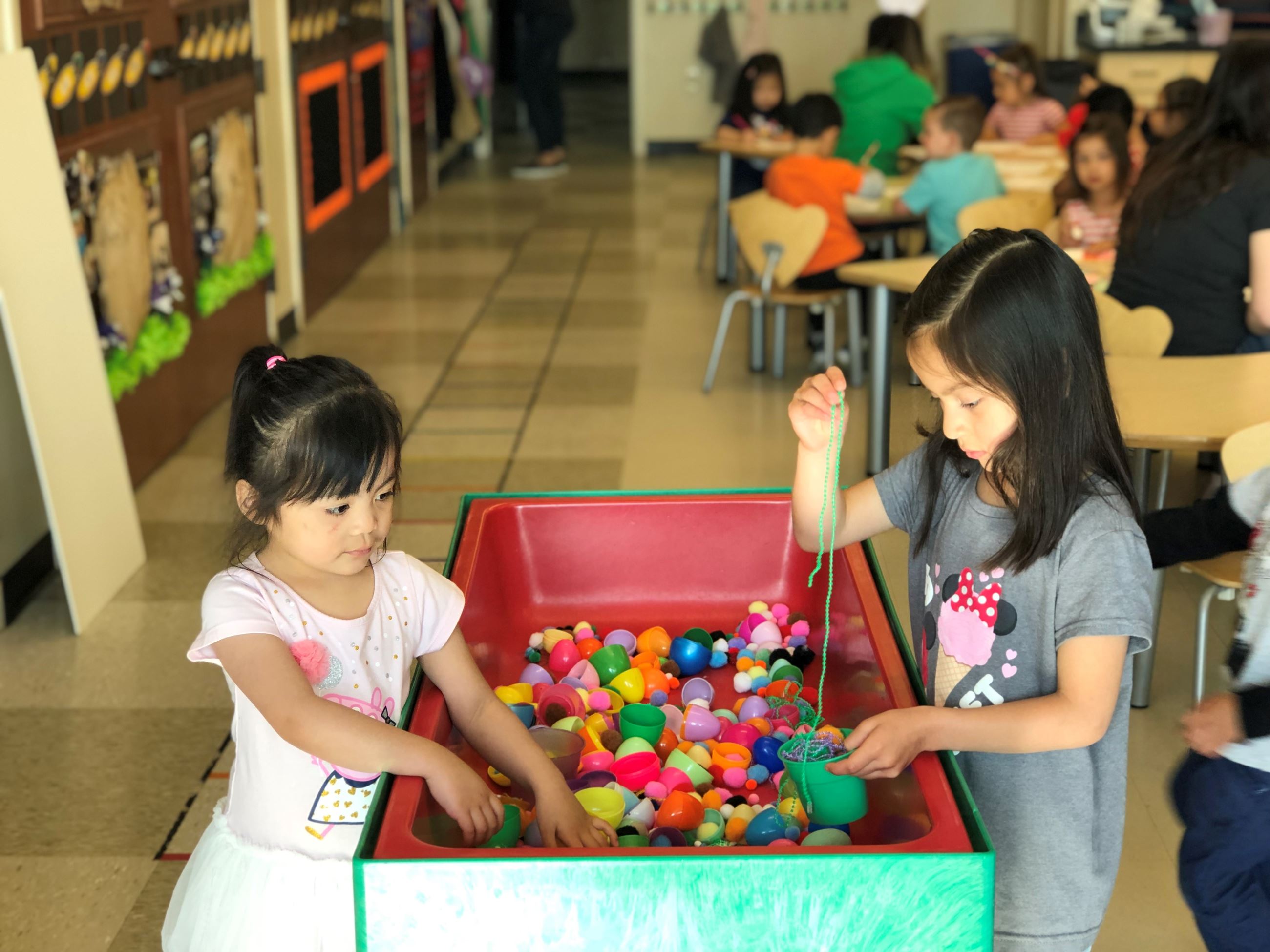 2 girls playing on sensory table